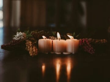 A lit candle beside a framed pet photo as a memorial keepsake