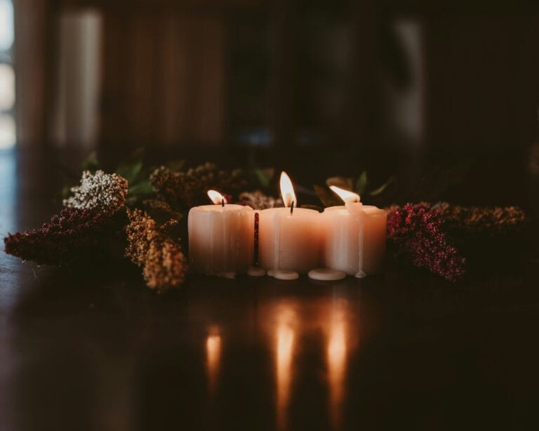 A lit candle beside a framed pet photo as a memorial keepsake